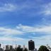 9月の残暑の残る青空の下に広がる都会の遠景の中のビル